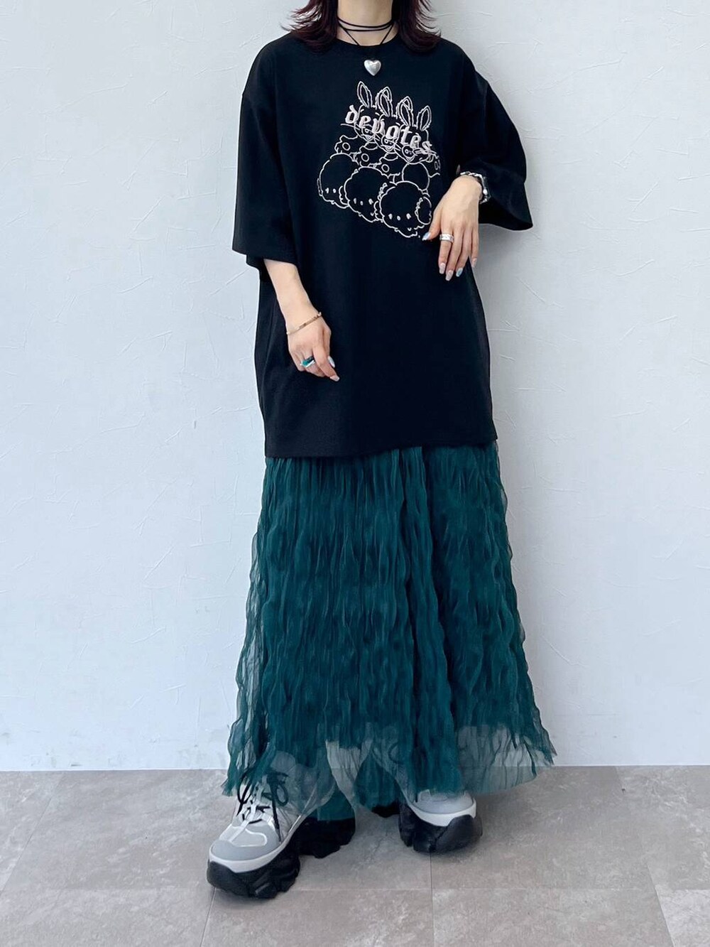 グレー系のスニーカー、グリーン系のスカート、ブラック系のチョーカーを着用したレディースの夏コーディネートの5枚目の写真