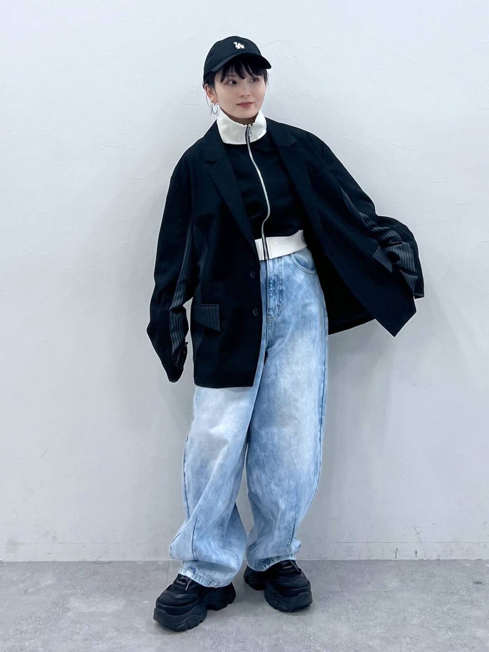 ブラック系のテーラードジャケット、ブラック系のスニーカー、ブラック系のジャージを着用したレディースの春コーディネートの6枚目の写真