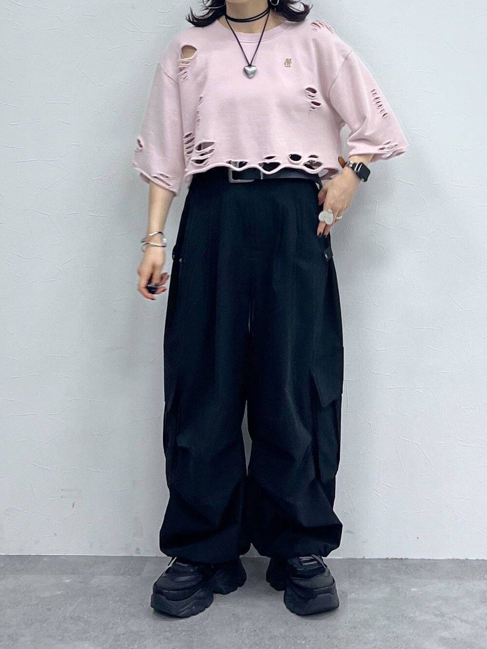 ブラック系のカーゴパンツ、ブラック系のスニーカー、ピンク系のTシャツ/カットソーを着用したレディースの秋コーディネートの6枚目の写真