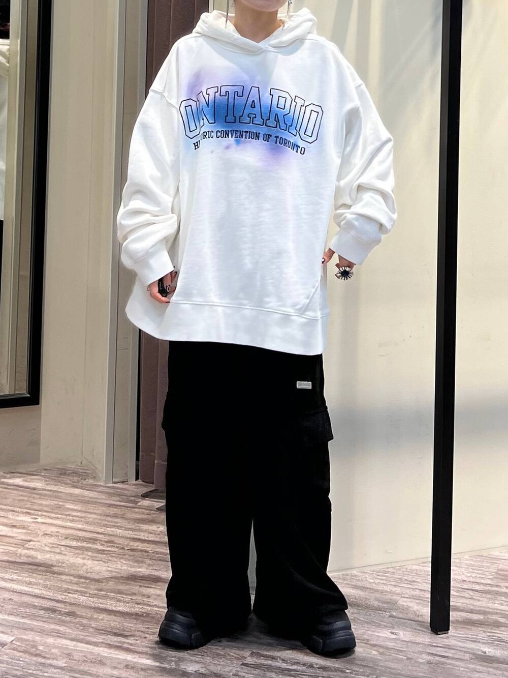 ブラック系のカーゴパンツ、ブラック系のブーツ、ホワイト系のパーカーを着用したレディースの冬コーディネートの7枚目の写真