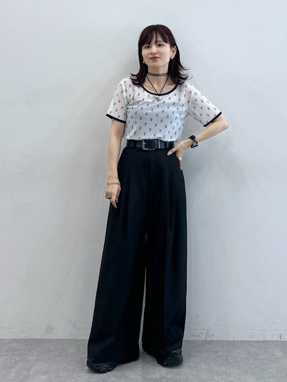 ブラック系のスニーカー、ホワイト系のTシャツ/カットソー、ブラック系のスラックスを着用したレディースの夏コーディネートの5枚目の写真