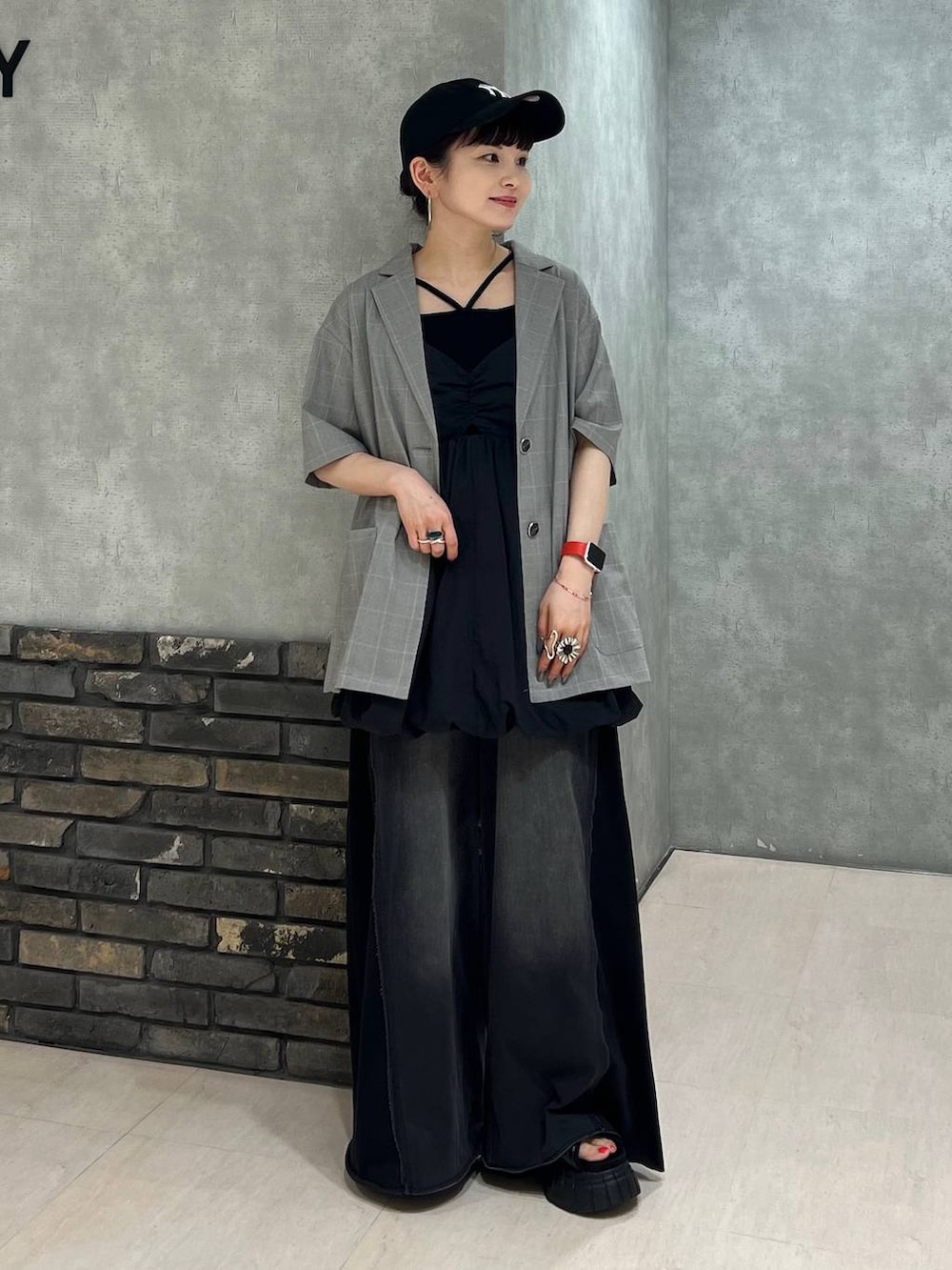 ブラック系のデニムパンツ、ベージュ系のテーラードジャケット、ブラック系のワンピースを着用したレディースの夏コーディネートの2枚目の写真