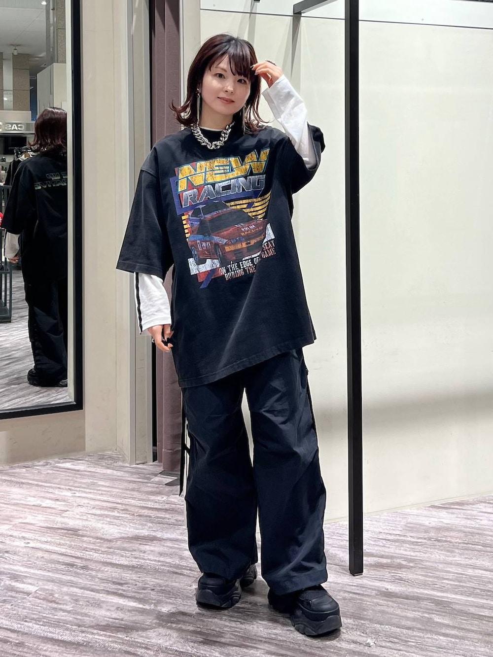 ブラック系のスニーカー、ブラック系のカーゴパンツ、ブラック系のTシャツ/カットソーを着用したレディースの春コーディネートの2枚目の写真