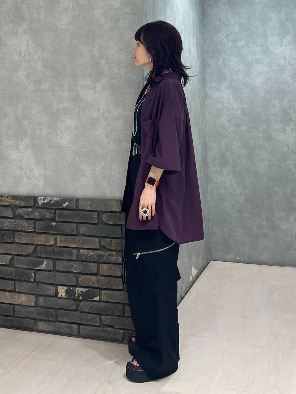 ブラック系のカーゴパンツ、レッド系のシャツ/ブラウス、ブラック系のベルトを着用したレディースの秋コーディネートの3枚目の写真