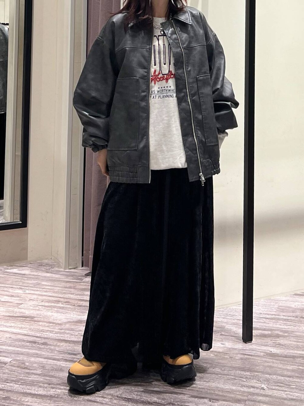 ブラック系のデニムパンツ、ブラウン系のブーツ、グレー系のブルゾンを着用したレディースの秋コーディネートの5枚目の写真