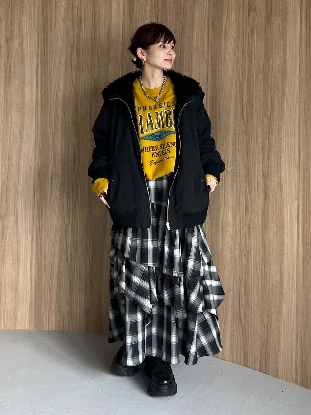 ブラック系のブーツ、イエロー系のスウェット、ブラック系のブルゾンを着用したレディースの秋コーディネートの5枚目の写真