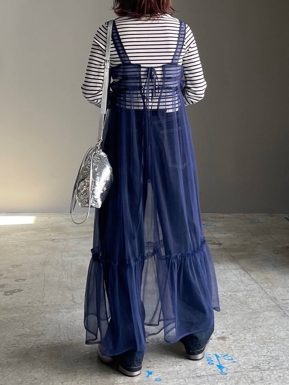 ブルー系のデニムパンツ、その他のブーツ、ブルー系のワンピースを着用したレディースの秋コーディネートの4枚目の写真