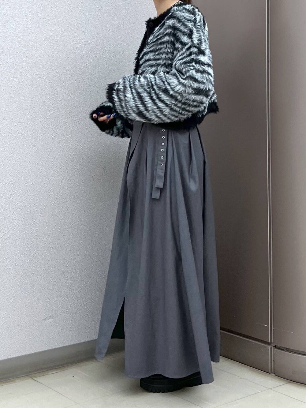 ブラック系のブーツ、グレー系のスカート、その他のカーディガン/ボレロを着用したレディースの秋コーディネートの3枚目の写真