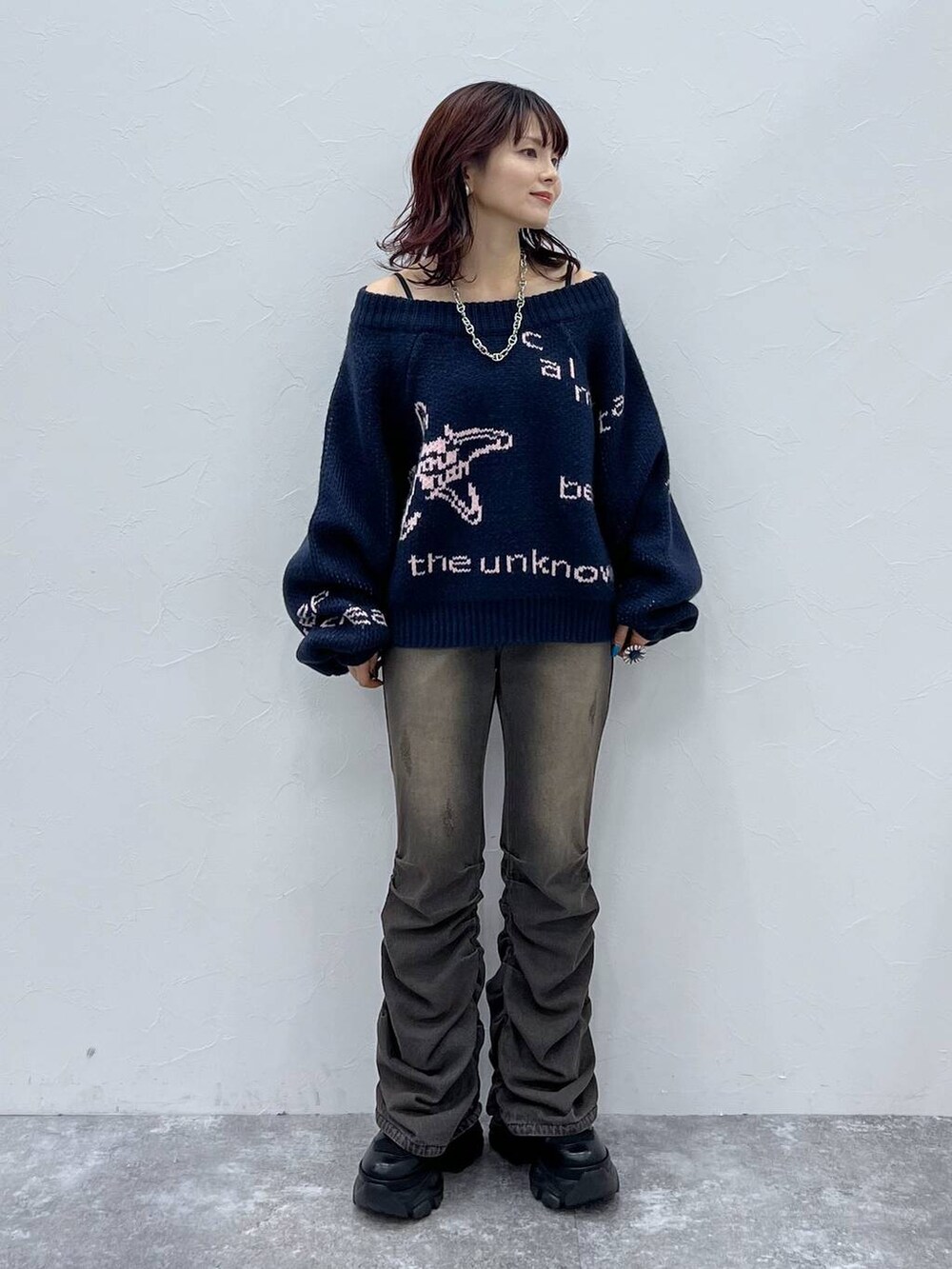 ブラック系のデニムパンツ、ブラック系のブーツ、ブルー系のニット/セーターを着用したレディースの冬コーディネートの2枚目の写真