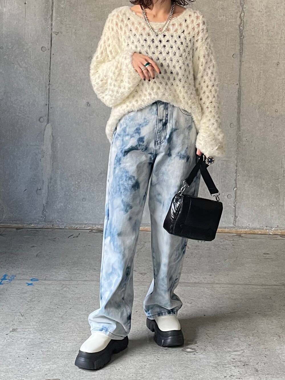 ブルー系のデニムパンツ、ホワイト系のブーツ、ホワイト系のニット/セーターを着用したレディースの秋コーディネートの6枚目の写真