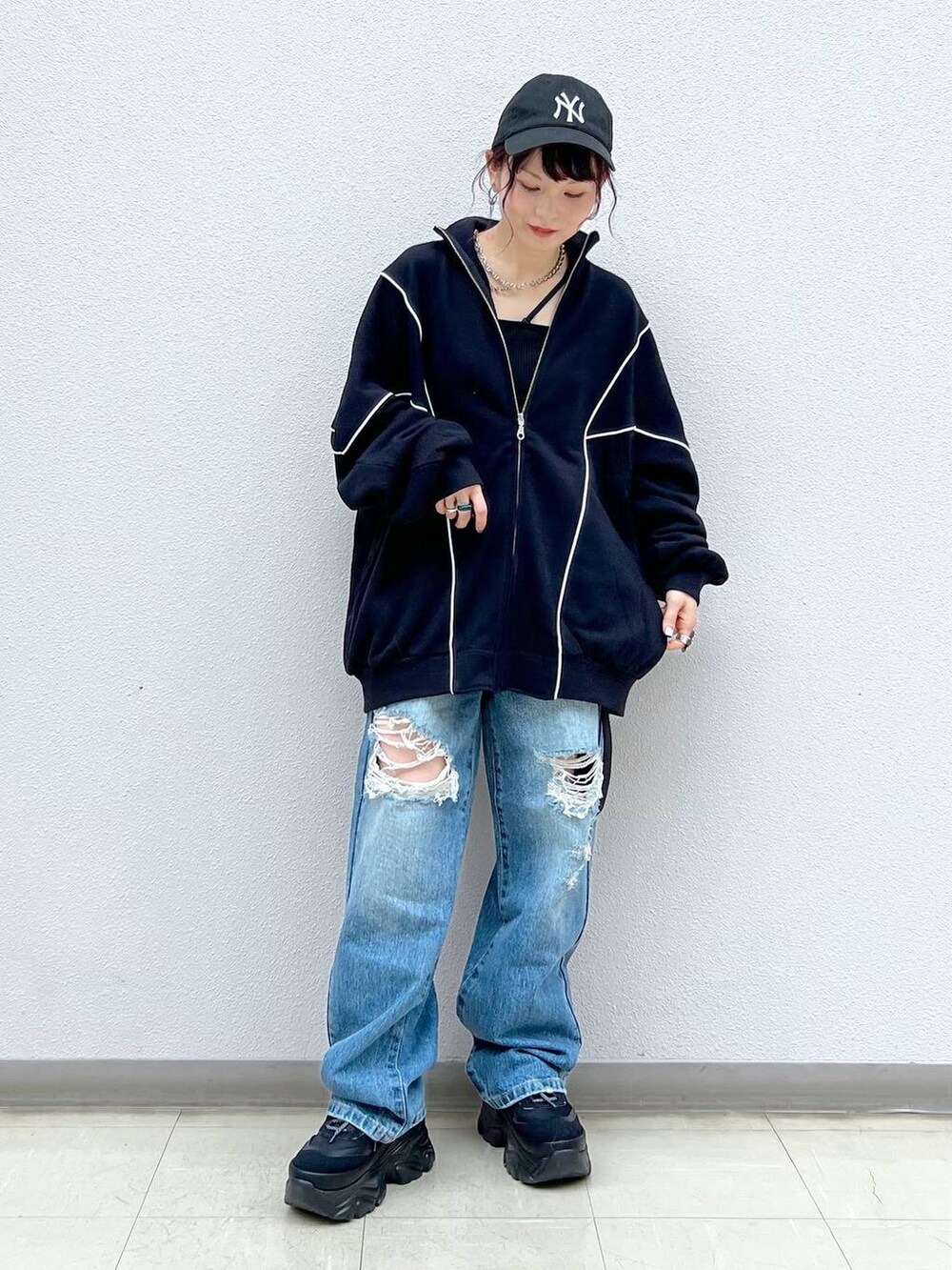 ブラック系のキャミソール、ブルー系のデニムパンツ、ブラック系のスニーカーを着用したレディースの春コーディネートの3枚目の写真