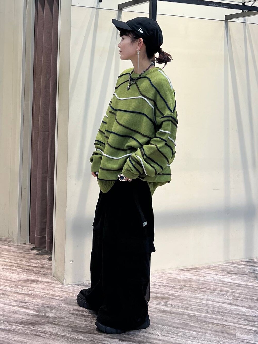 ブラック系のカーゴパンツ、グリーン系のニット/セーター、ブラック系のブーツを着用したレディースの冬コーディネートの3枚目の写真