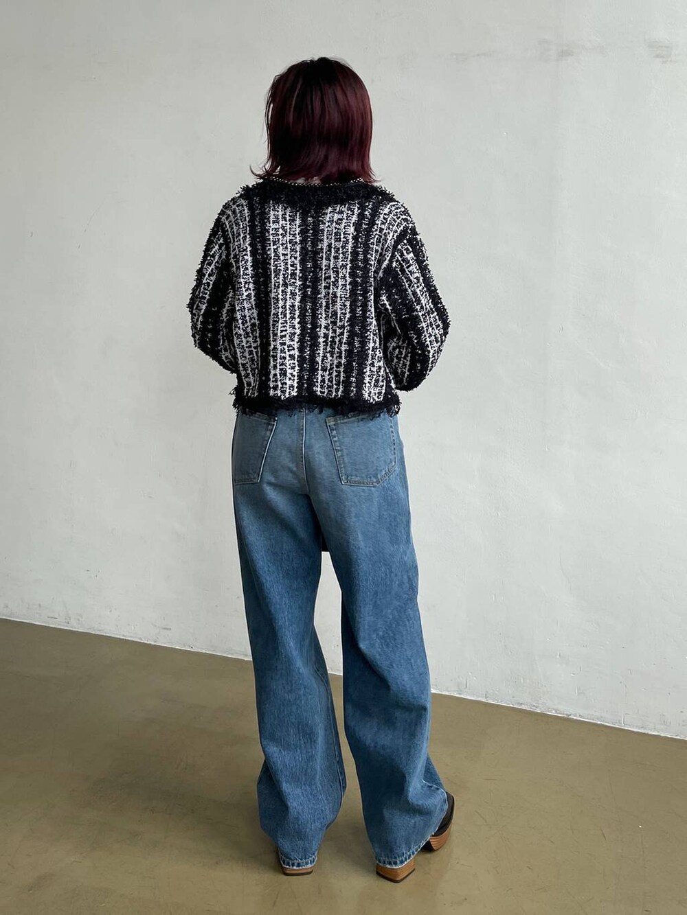 ブルー系のデニムパンツ、ブラック系のカーディガン/ボレロ、ホワイト系のTシャツ/カットソーを着用したレディースの秋コーディネートの3枚目の写真