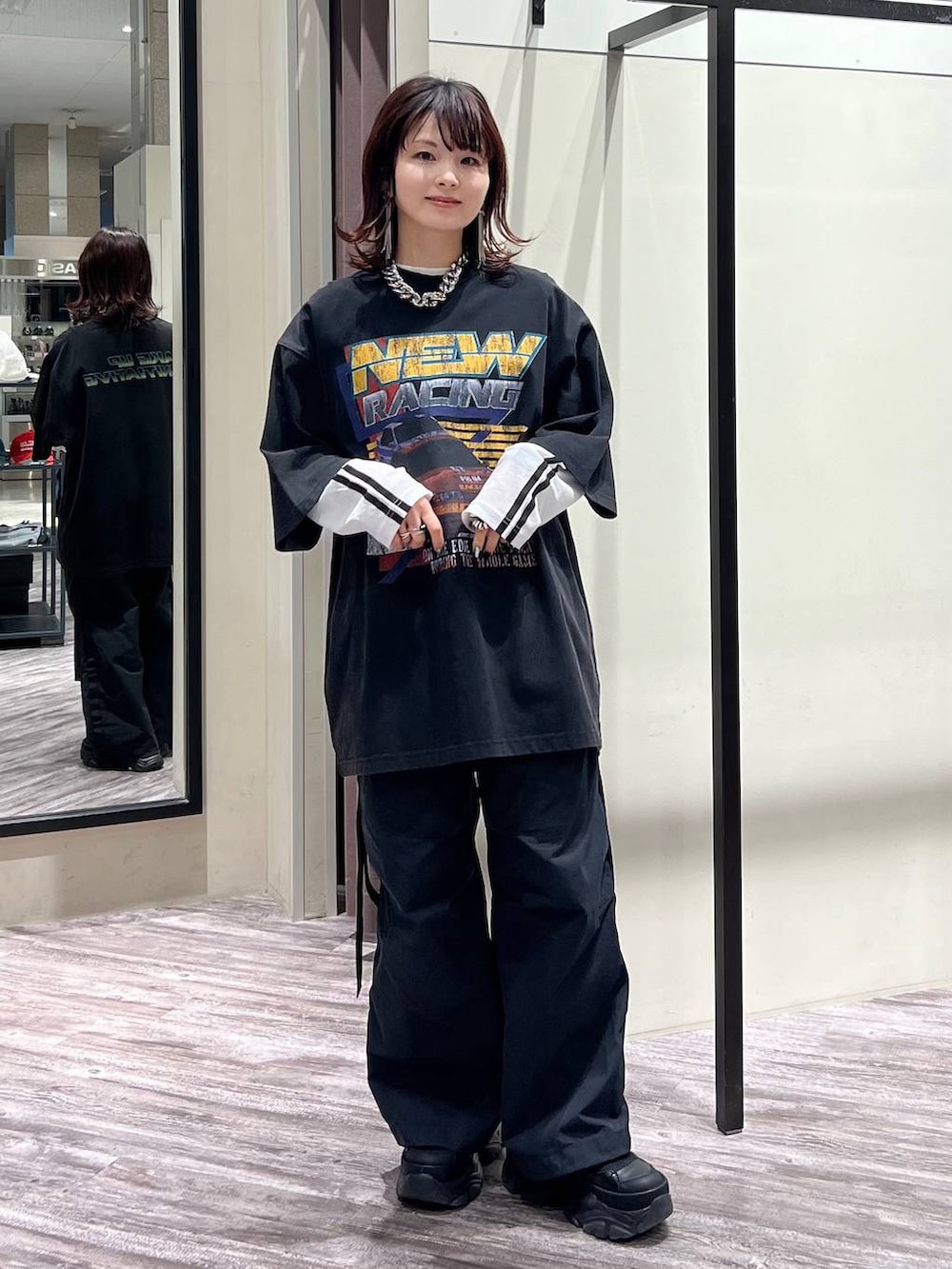 ブラック系のスニーカー、ブラック系のカーゴパンツ、ブラック系のTシャツ/カットソーを着用したレディースの春コーディネートの8枚目の写真