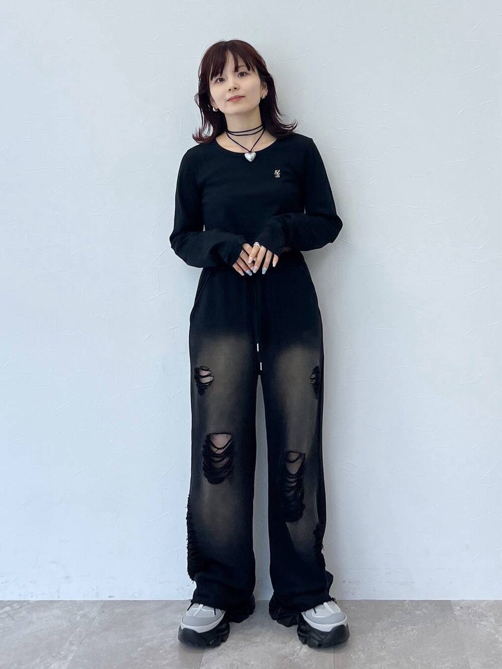 グレー系のスニーカー、ブラック系のスウェットパンツ、ブラック系のTシャツ/カットソーを着用したレディースの秋コーディネートの6枚目の写真