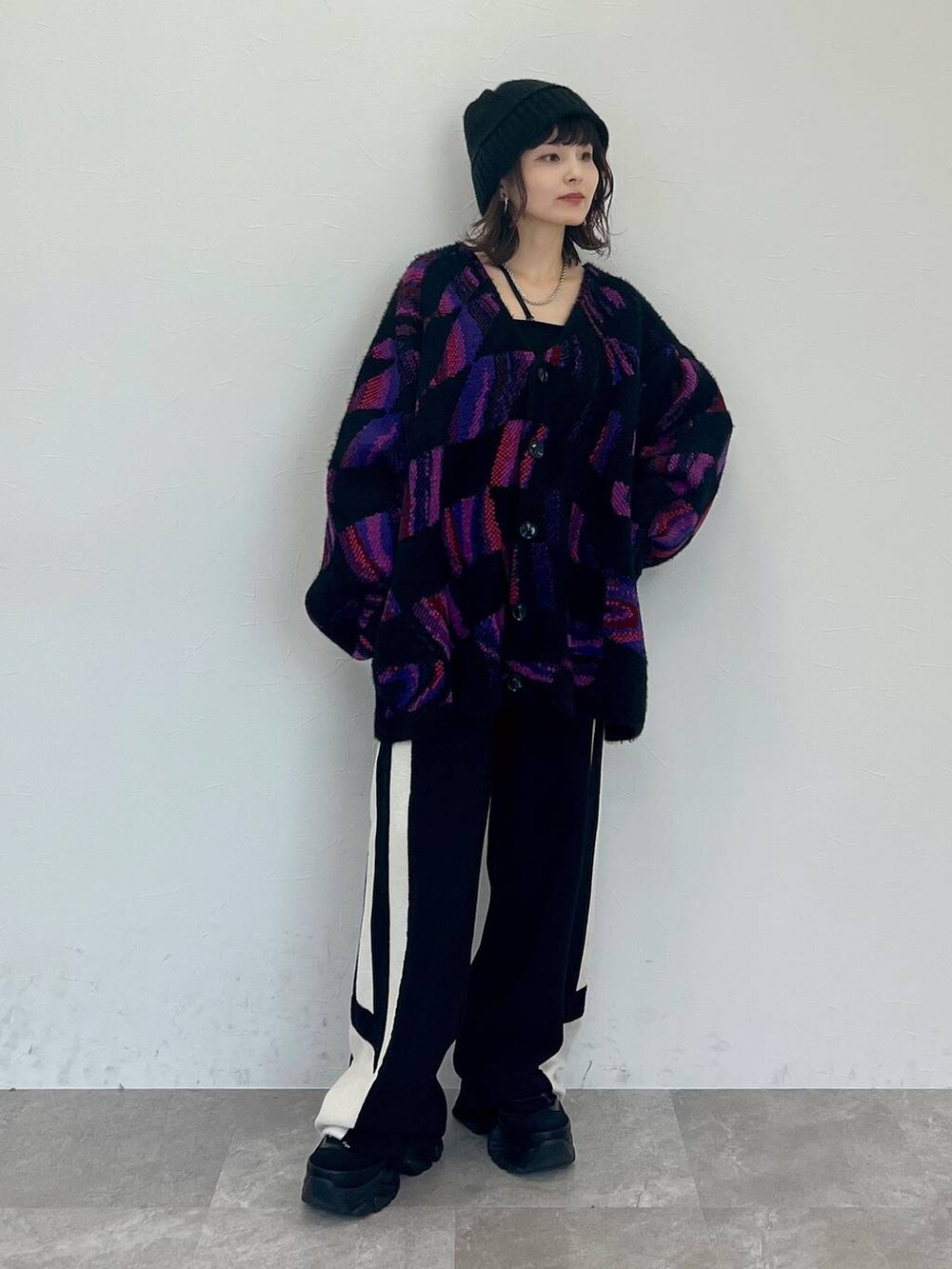 ブラック系のキャミソール、ブラック系のスウェットパンツ、ブラック系のスニーカーを着用したレディースの秋コーディネートの2枚目の写真