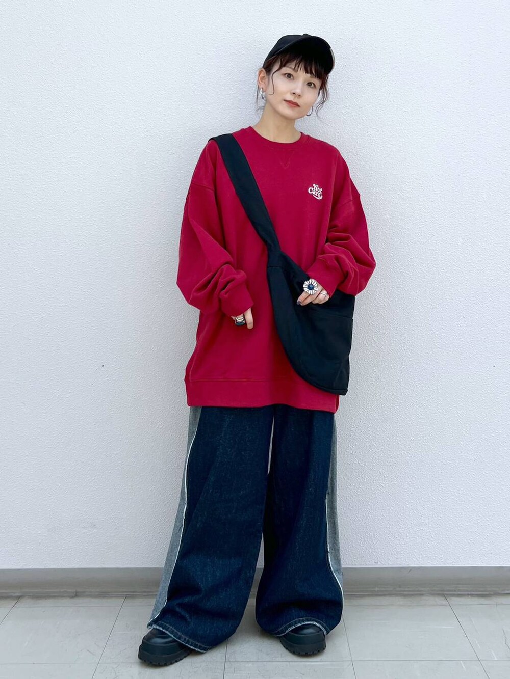 ブラック系のブーツ、ブラック系のショルダーバッグ、レッド系のスウェットを着用したレディースの秋コーディネートの2枚目の写真