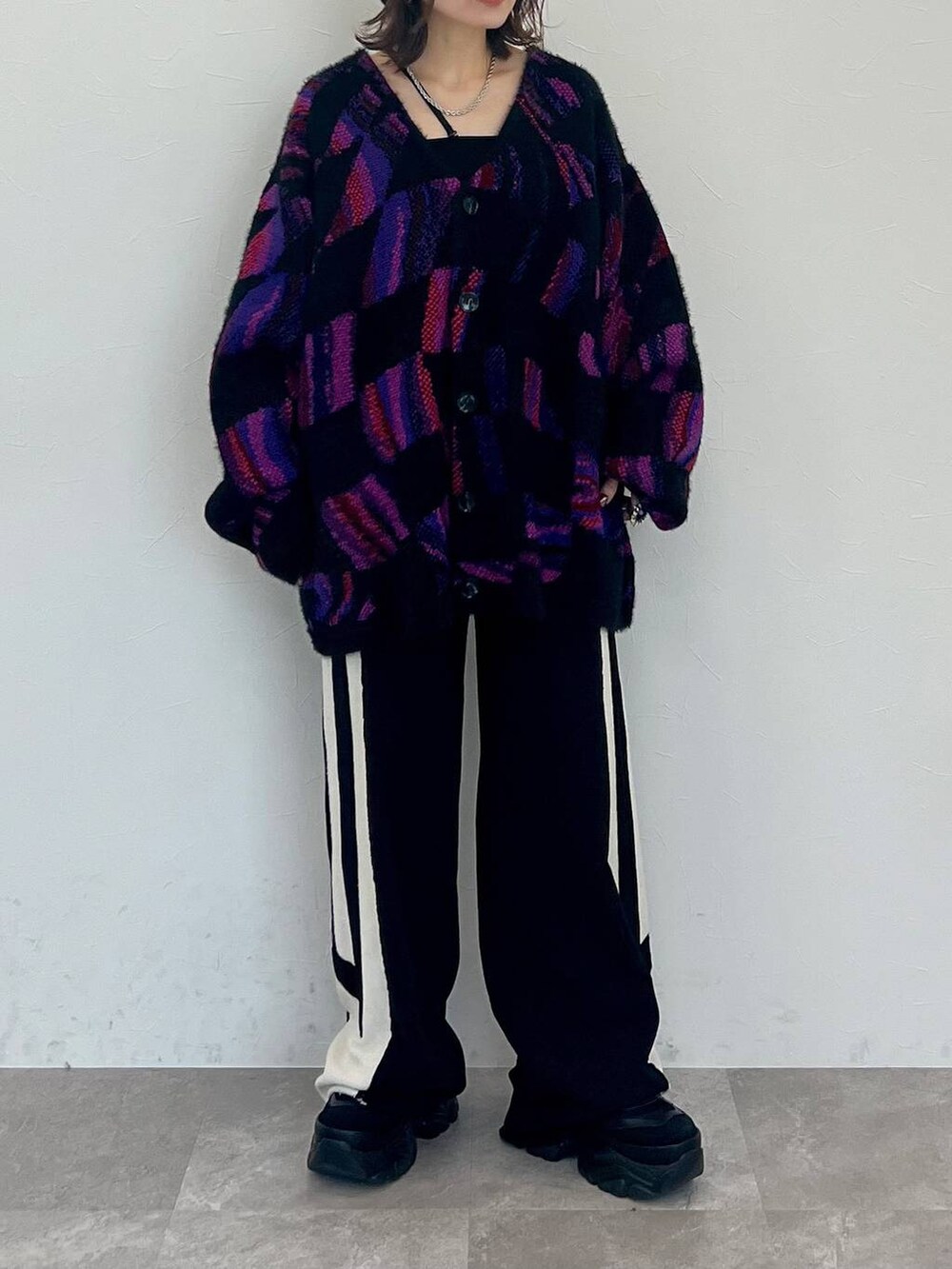 ブラック系のキャミソール、ブラック系のスウェットパンツ、ブラック系のスニーカーを着用したレディースの秋コーディネートの8枚目の写真