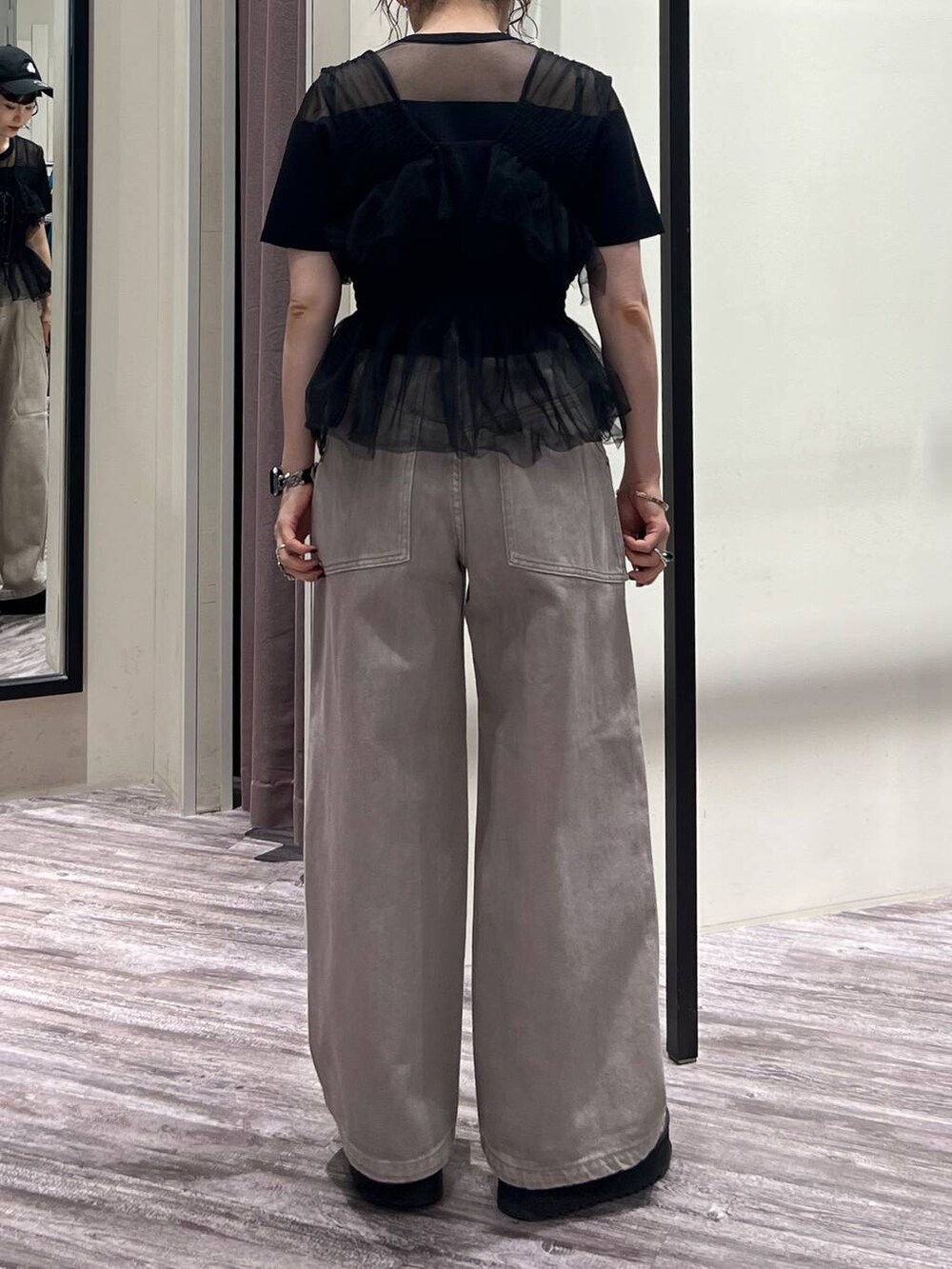 ブラック系のベスト、ブラック系のTシャツ/カットソー、ベージュ系のデニムパンツを着用したレディースの夏コーディネートの5枚目の写真