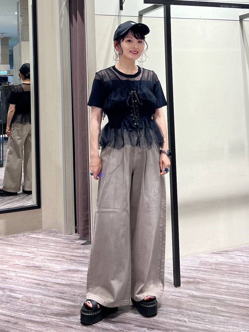 ブラック系のベスト、ブラック系のTシャツ/カットソー、ベージュ系のデニムパンツを着用したレディースの夏コーディネートの7枚目の写真