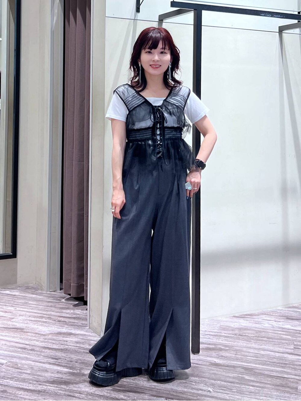 ブラック系のスニーカー、グレー系のスラックス、ブラック系のベストを着用したレディースの夏コーディネートの2枚目の写真