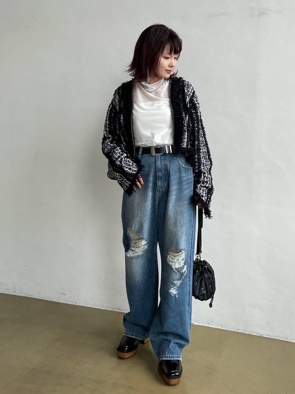 ブルー系のデニムパンツ、ブラック系のカーディガン/ボレロ、ホワイト系のTシャツ/カットソーを着用したレディースの秋コーディネートの2枚目の写真