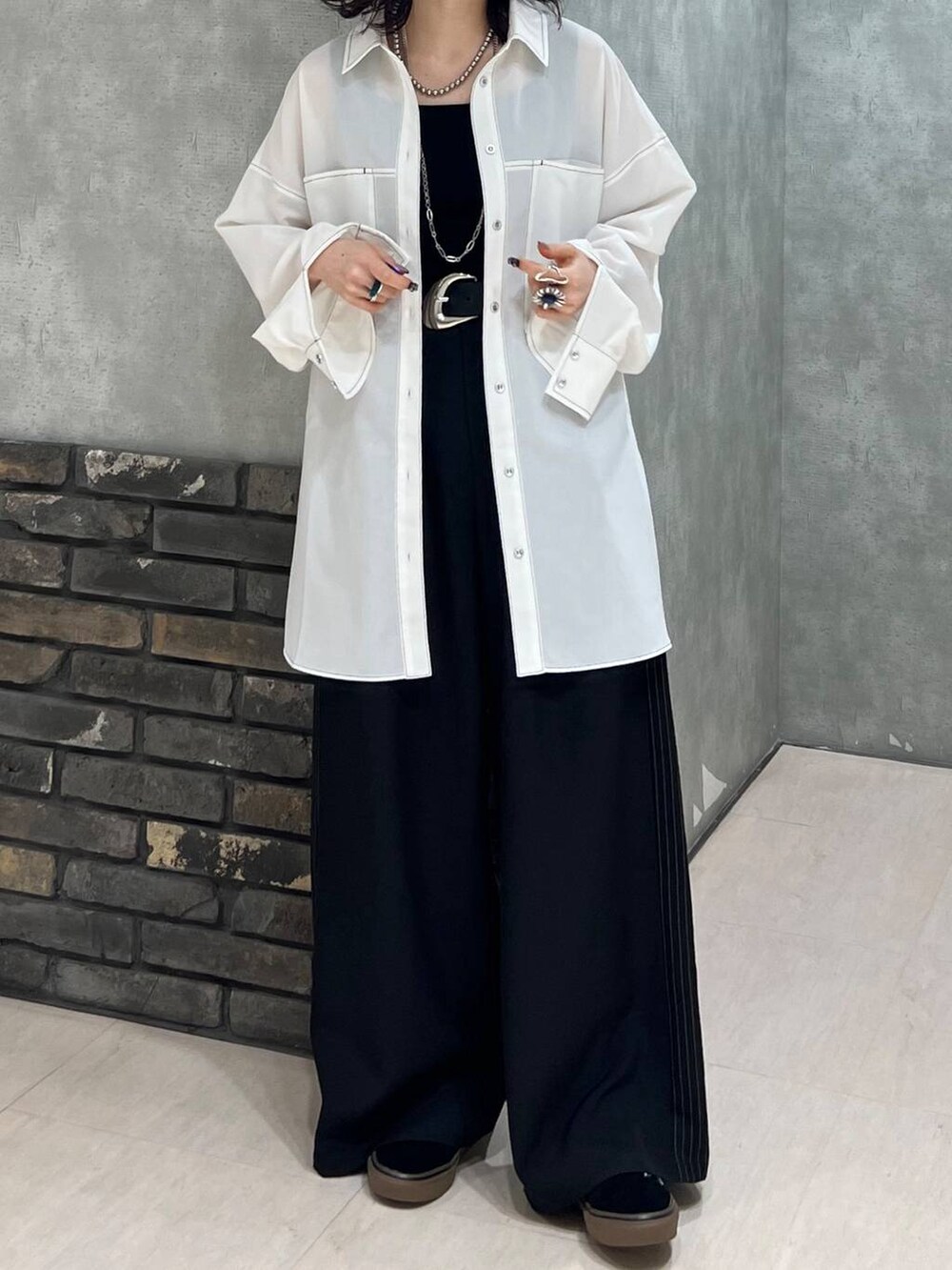 ブラック系のスラックス、ブラック系のタンクトップ、ブラック系のベルトを着用したレディースの春コーディネートの4枚目の写真