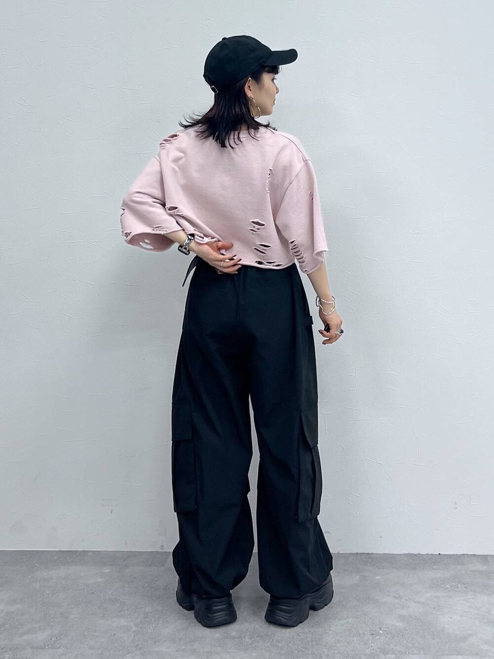 ブラック系のカーゴパンツ、ブラック系のスニーカー、ピンク系のTシャツ/カットソーを着用したレディースの秋コーディネートの4枚目の写真