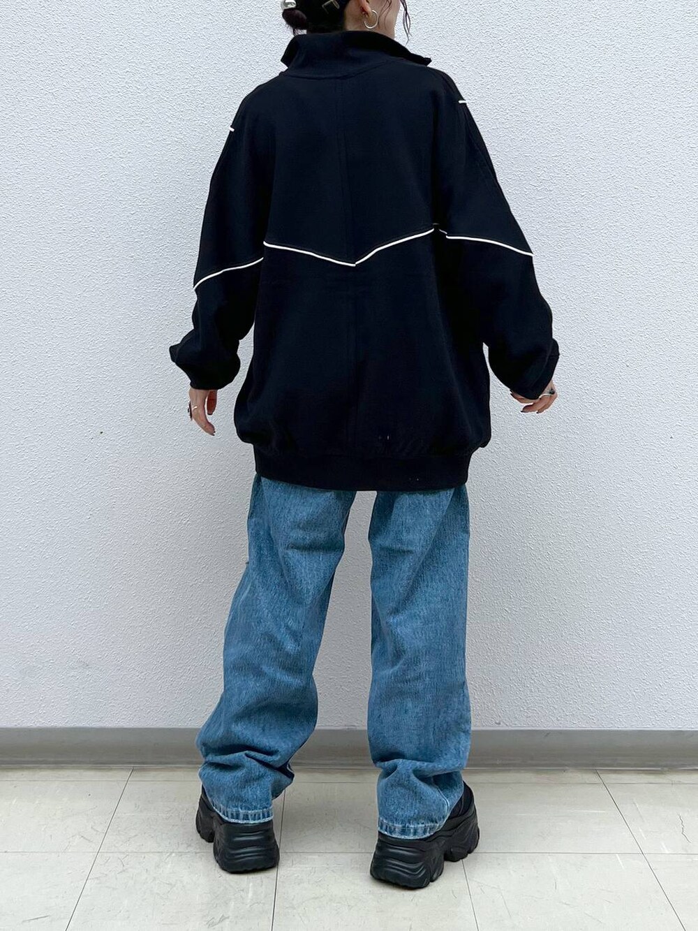 ブラック系のキャミソール、ブルー系のデニムパンツ、ブラック系のスニーカーを着用したレディースの春コーディネートの6枚目の写真