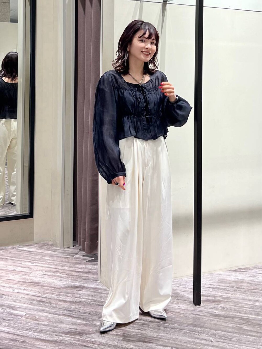 シルバー系のパンプス、ホワイト系のスラックス、ブラック系のシャツ/ブラウスを着用したレディースの春コーディネートの6枚目の写真