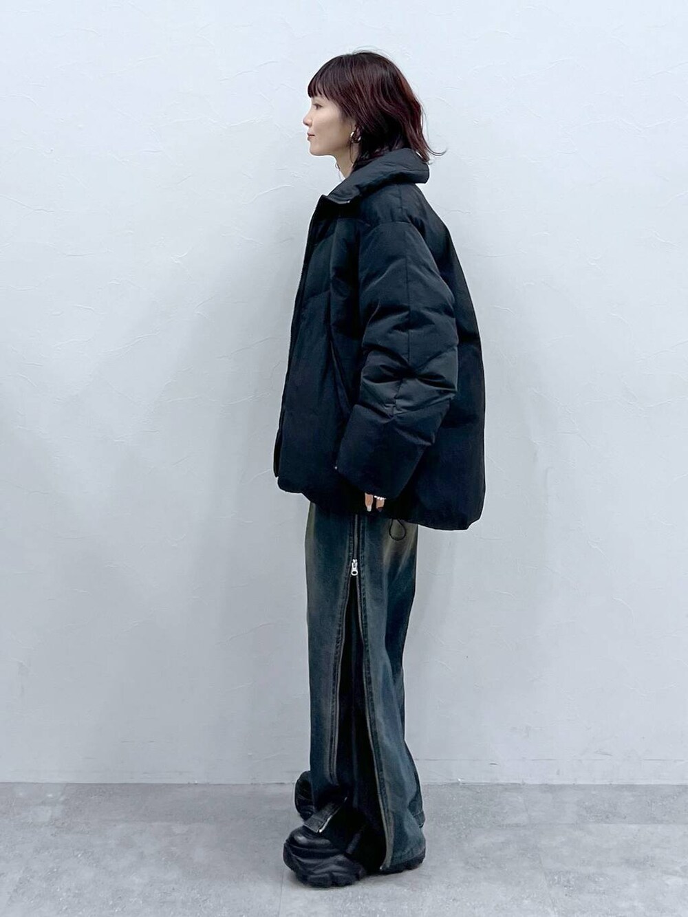 ブラック系のブーツ、ブラック系のブルゾン、グリーン系のニット/セーターを着用したレディースの冬コーディネートの2枚目の写真