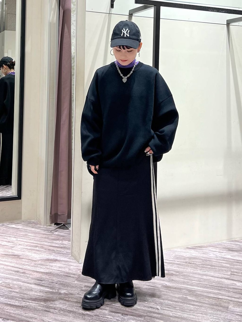 ブラック系のニット/セーター、パープル系のTシャツ/カットソー、ブラック系のスニーカーを着用したレディースの冬コーディネートの2枚目の写真