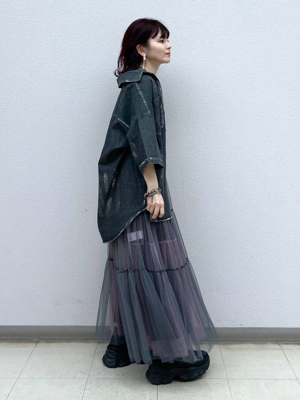 ブラック系のスニーカー、グレー系のスカート、ブラック系のシャツ/ブラウスを着用したレディースの夏コーディネートの3枚目の写真