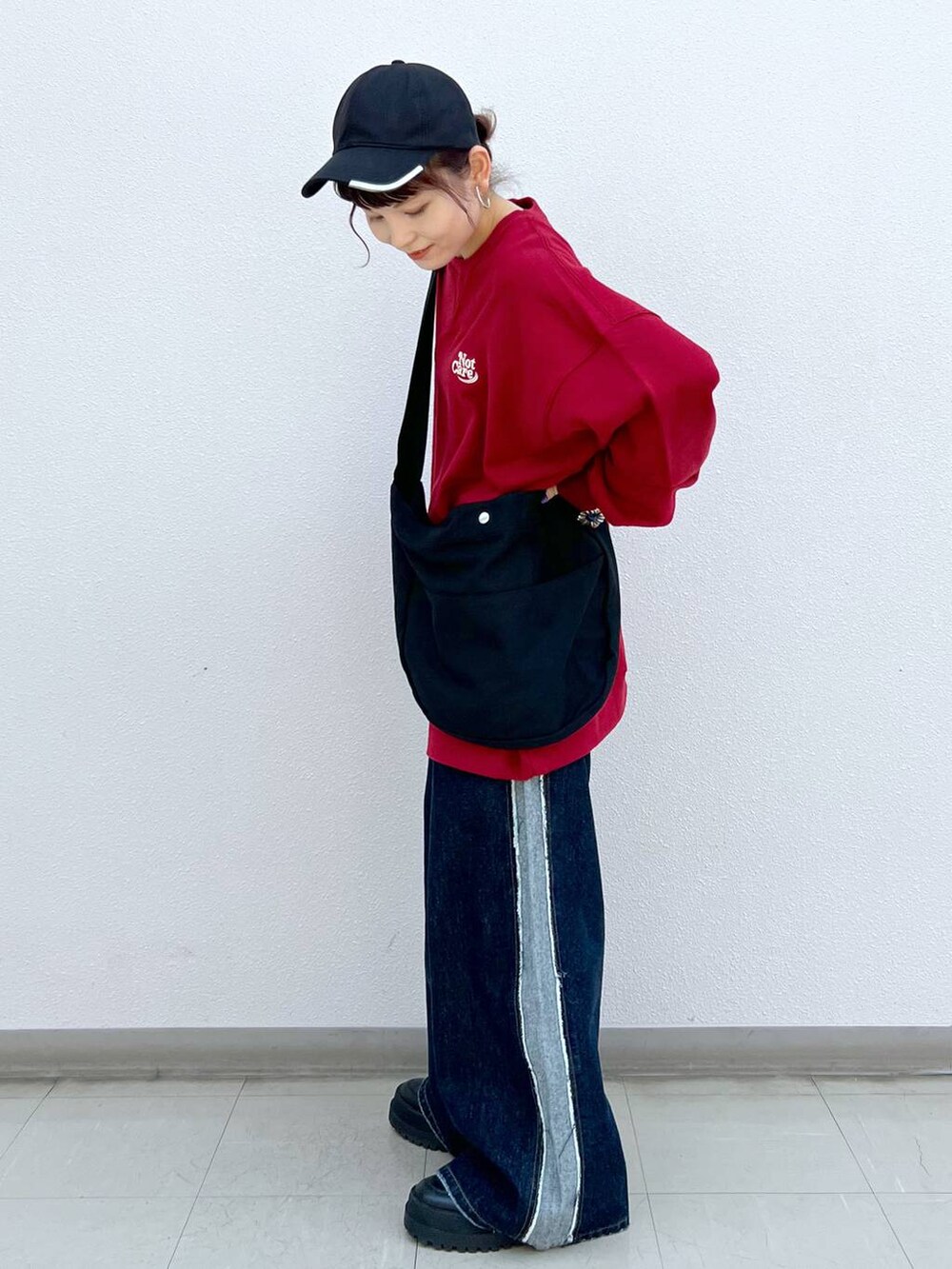 ブラック系のブーツ、ブラック系のショルダーバッグ、レッド系のスウェットを着用したレディースの秋コーディネートの4枚目の写真