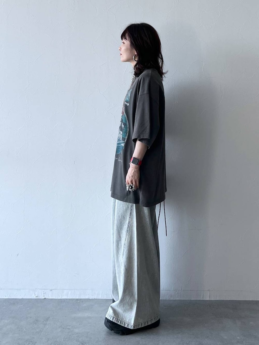 ブラック系のスニーカー、ブルー系のデニムパンツ、グレー系のTシャツ/カットソーを着用したレディースの夏コーディネートの3枚目の写真