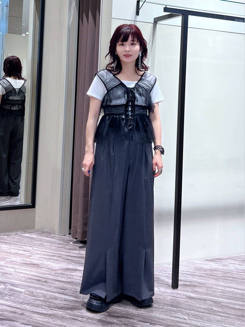 ブラック系のスニーカー、グレー系のスラックス、ブラック系のベストを着用したレディースの夏コーディネートの7枚目の写真