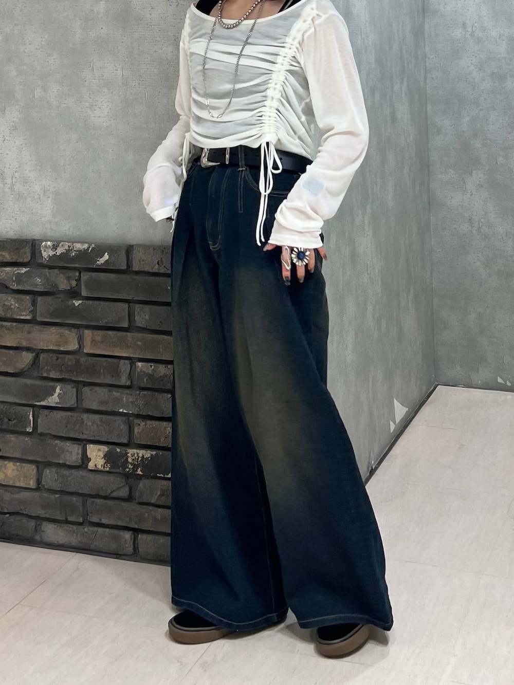 ブルー系のデニムパンツ、ブラック系のタンクトップ、ホワイト系のTシャツ/カットソーを着用したレディースの春コーディネートの5枚目の写真