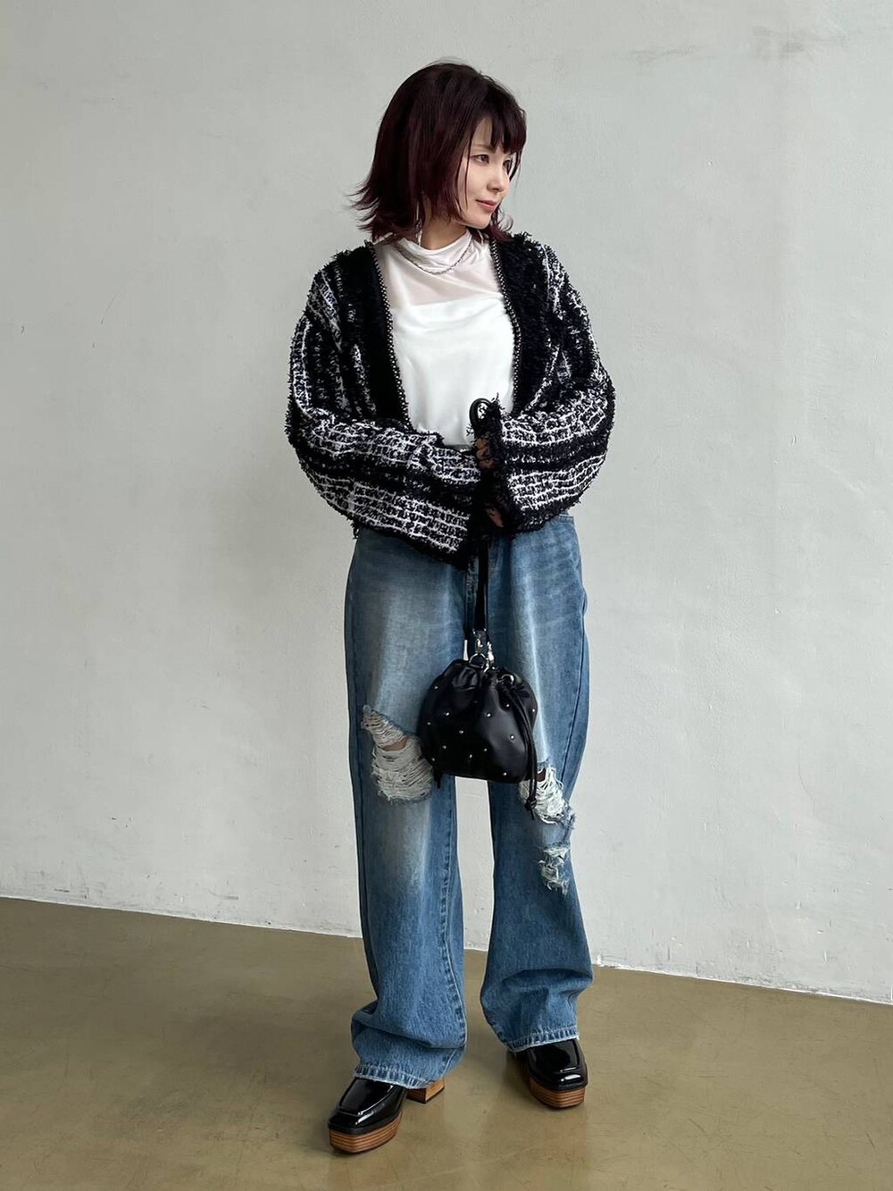 ブルー系のデニムパンツ、ブラック系のカーディガン/ボレロ、ホワイト系のTシャツ/カットソーを着用したレディースの秋コーディネートの5枚目の写真