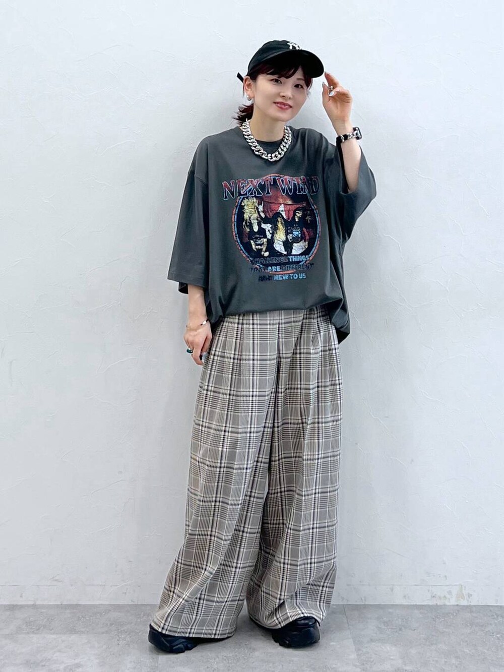 ブラック系のスニーカー、グレー系のTシャツ/カットソー、ベージュ系のスラックスを着用したレディースの秋コーディネートの6枚目の写真