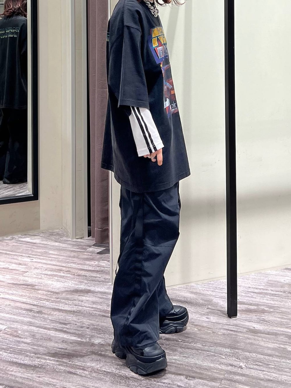 ブラック系のスニーカー、ブラック系のカーゴパンツ、ブラック系のTシャツ/カットソーを着用したレディースの春コーディネートの5枚目の写真