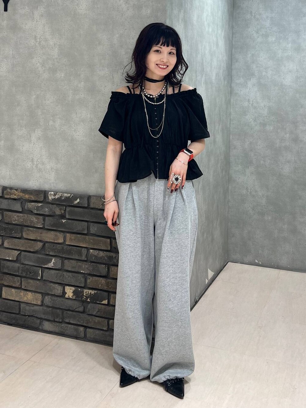 ブラック系のパンプス、ブラック系のシャツ/ブラウス、グレー系のスウェットパンツを着用したレディースの春コーディネートの2枚目の写真