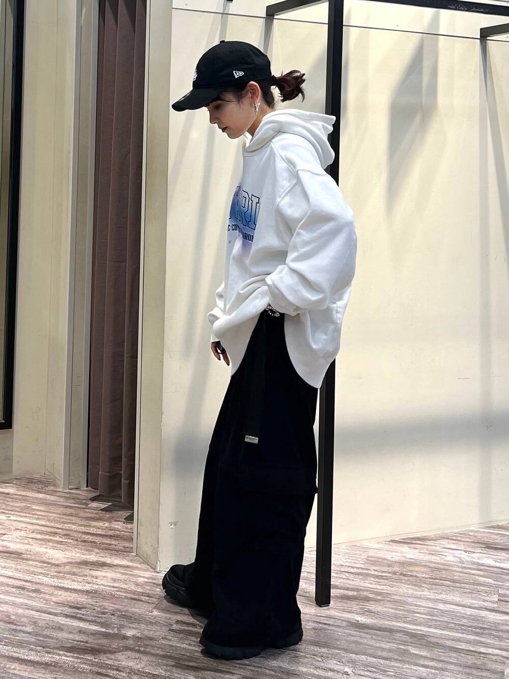 ブラック系のカーゴパンツ、ブラック系のブーツ、ホワイト系のパーカーを着用したレディースの冬コーディネートの3枚目の写真