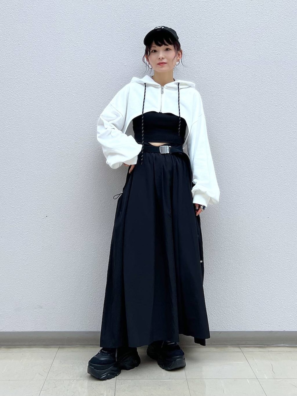 ブラック系のキャミソール、ブラック系のスニーカー、ホワイト系のパーカーを着用したレディースの秋コーディネートの2枚目の写真