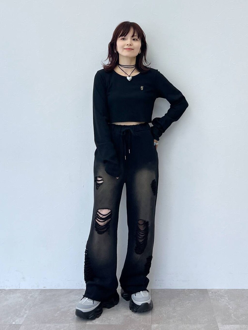 グレー系のスニーカー、ブラック系のスウェットパンツ、ブラック系のTシャツ/カットソーを着用したレディースの秋コーディネートの7枚目の写真