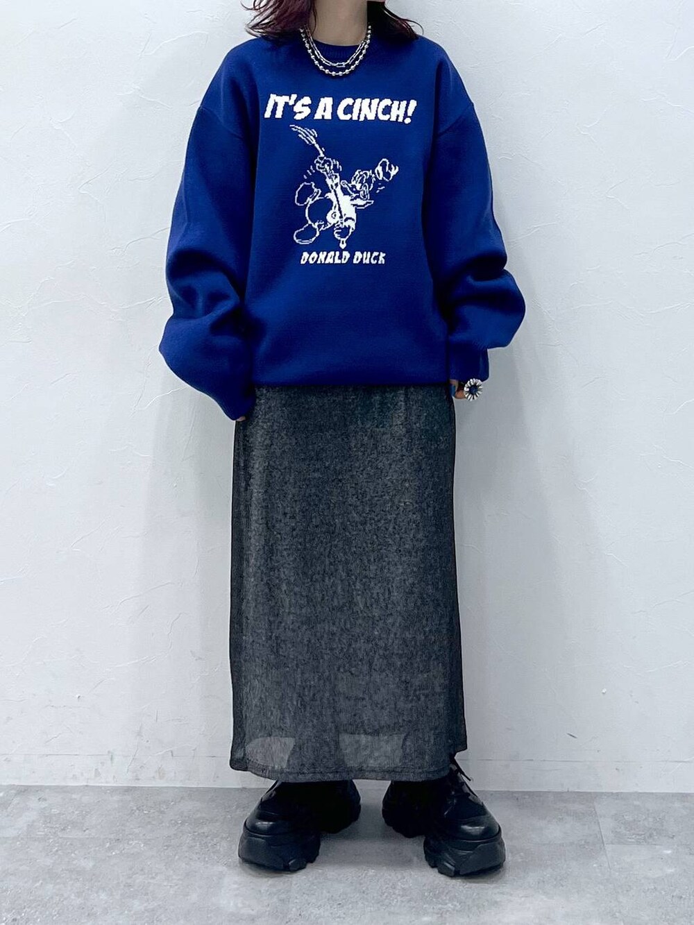 ブラック系のブーツ、ブラック系のスカート、ブルー系のニット/セーターを着用したレディースの冬コーディネートの5枚目の写真