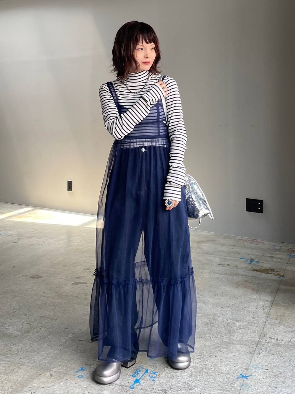 ブルー系のデニムパンツ、その他のブーツ、ブルー系のワンピースを着用したレディースの秋コーディネートの7枚目の写真