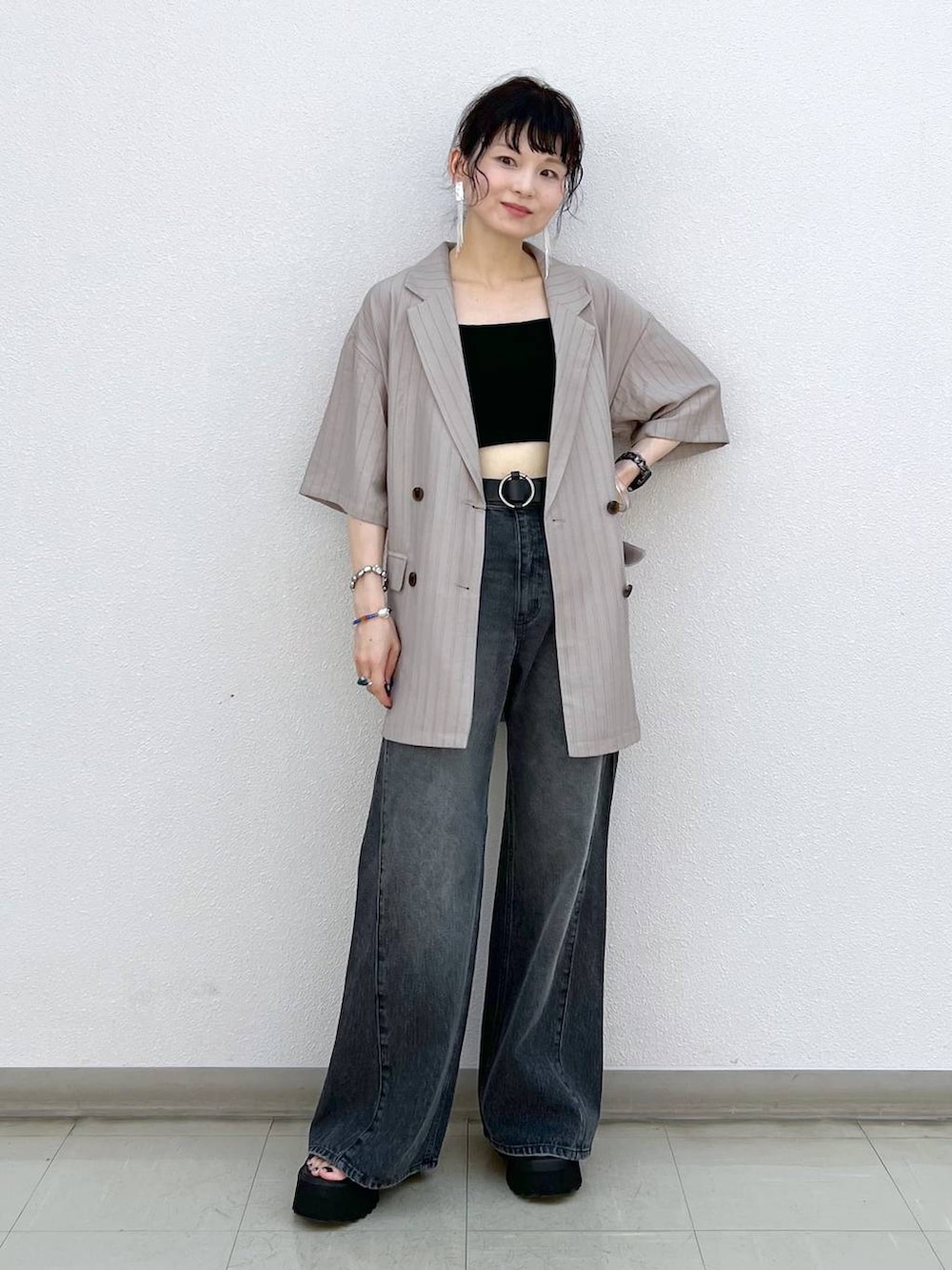 ブラック系のデニムパンツ、ブラック系のサンダル、ブラウン系のテーラードジャケットを着用したレディースの秋コーディネートの7枚目の写真
