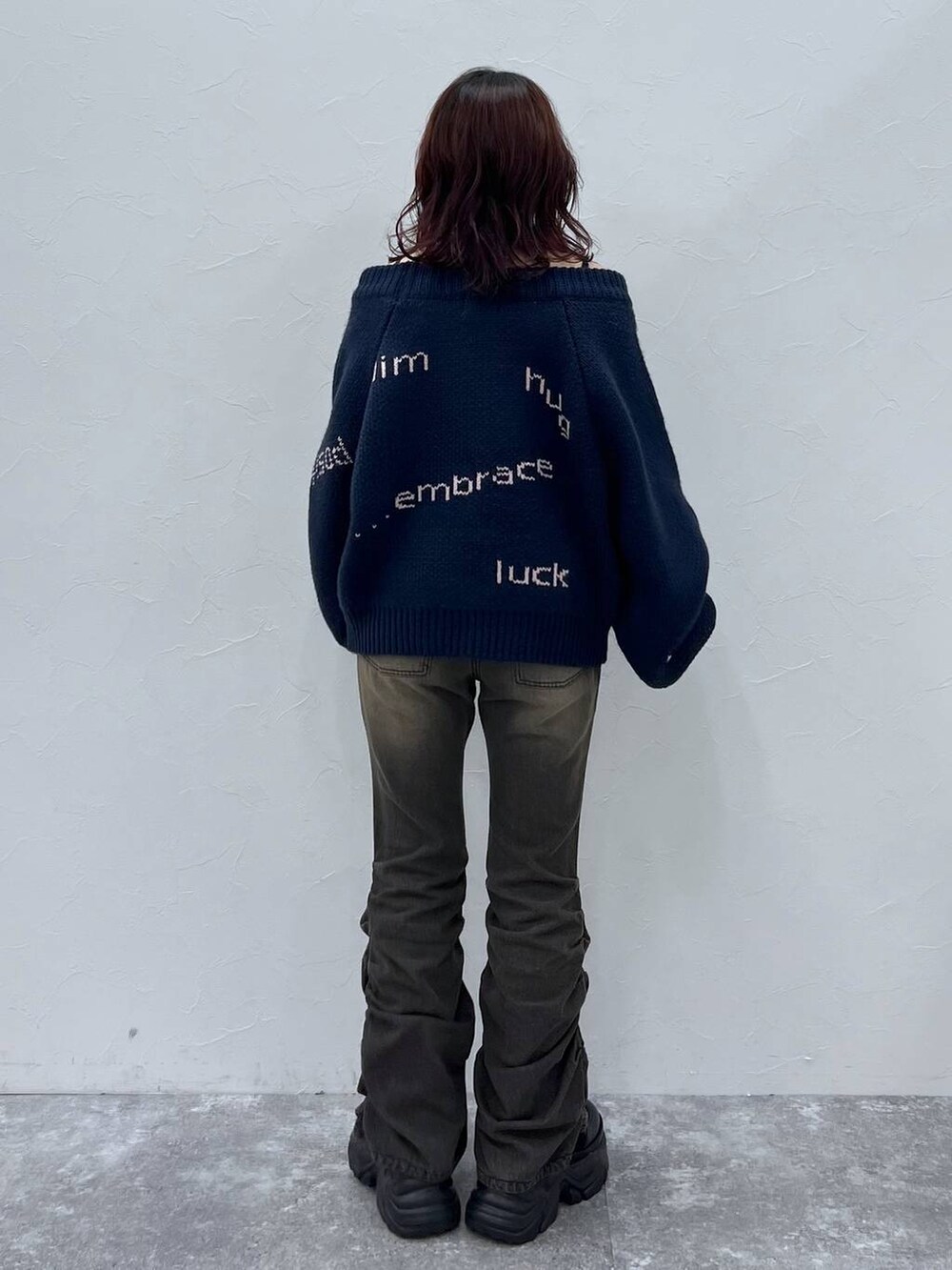 ブラック系のデニムパンツ、ブラック系のブーツ、ブルー系のニット/セーターを着用したレディースの冬コーディネートの4枚目の写真