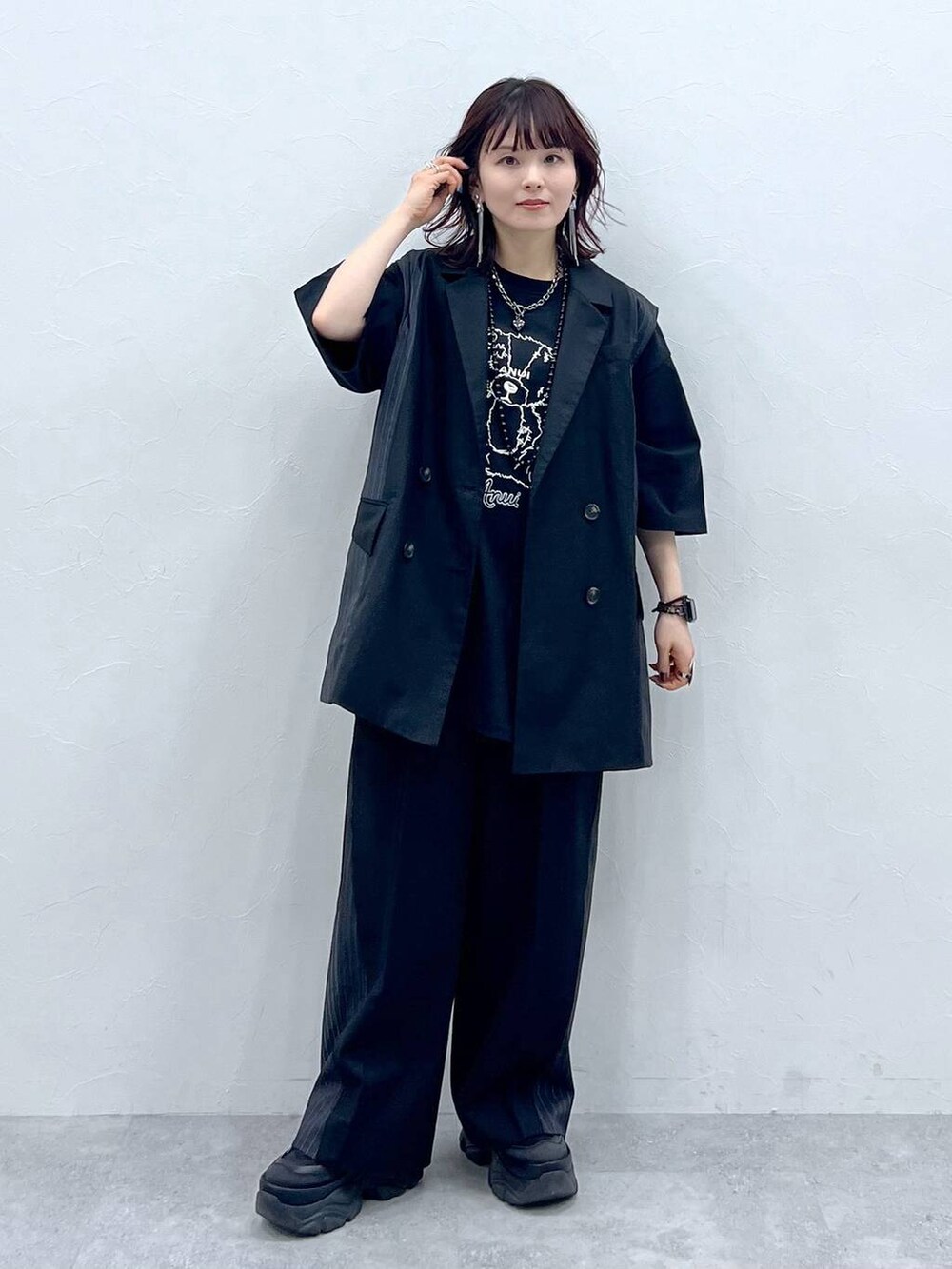 ブラック系のスラックス、ブラック系のTシャツ/カットソー、ブラック系のスニーカーを着用したレディースの春コーディネートの7枚目の写真