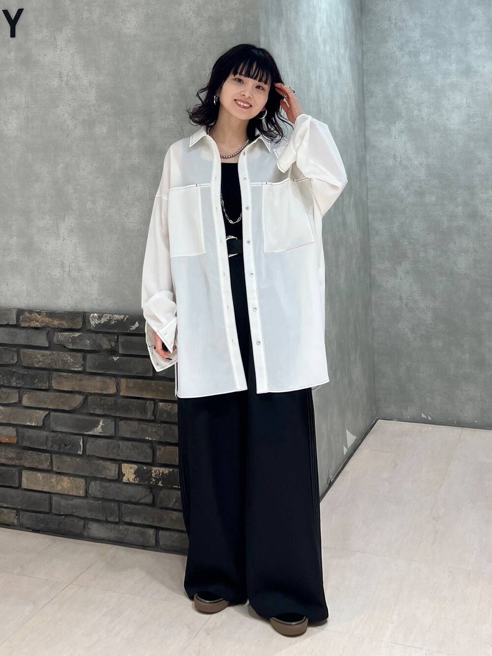 ブラック系のスラックス、ブラック系のタンクトップ、ブラック系のベルトを着用したレディースの春コーディネートの5枚目の写真